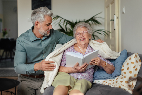 Senior woman spending nice time with his adult son,reading a book, concept of relationships.