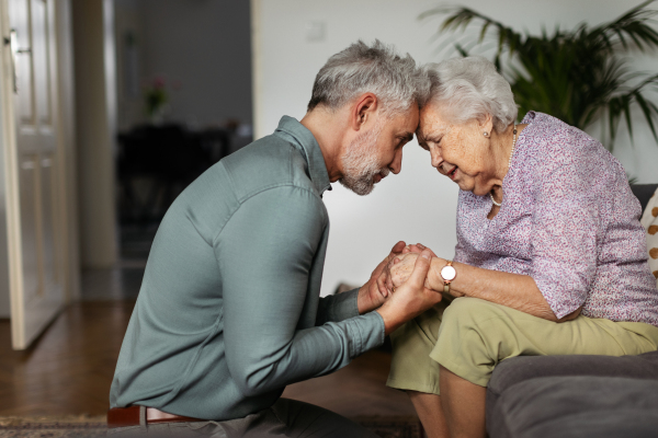 Portrait of mature man with his senior mother. Coping with grief, loss together.