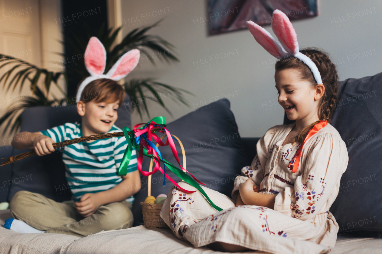 Boy holding handmade whip, made of willow branches, decorated with ribbons. Unique easter custom from slovakia, gently whipping woman and tranditional verses and easter wishes. Concept of Slovakian easter custom.