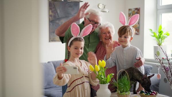 Grandparents taking selfie with grandchildren before traditional easter lunch. Recreating family traditions and customs. Concept of family easter holidays.