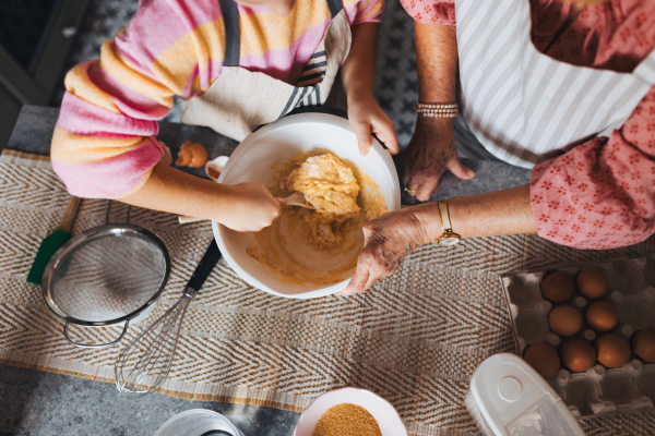 Top view of cake batter. Grandmother with grandaughter preparing traditional easter meals, baking cakes and sweets. Passing down family recipes, custom and stories. Concept of family easter holidays.