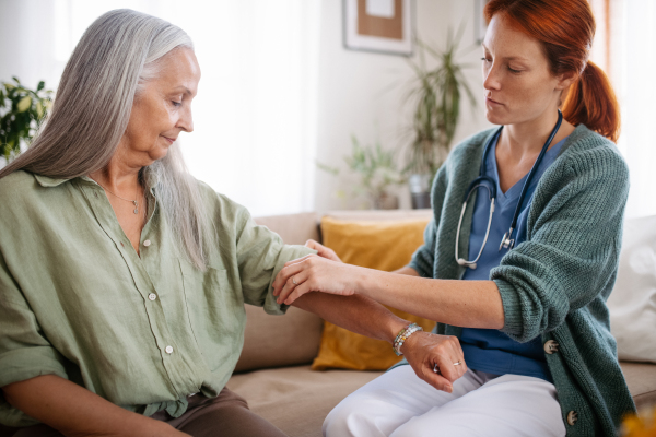 Nurse cosulting with senior woman her health condition at her home.