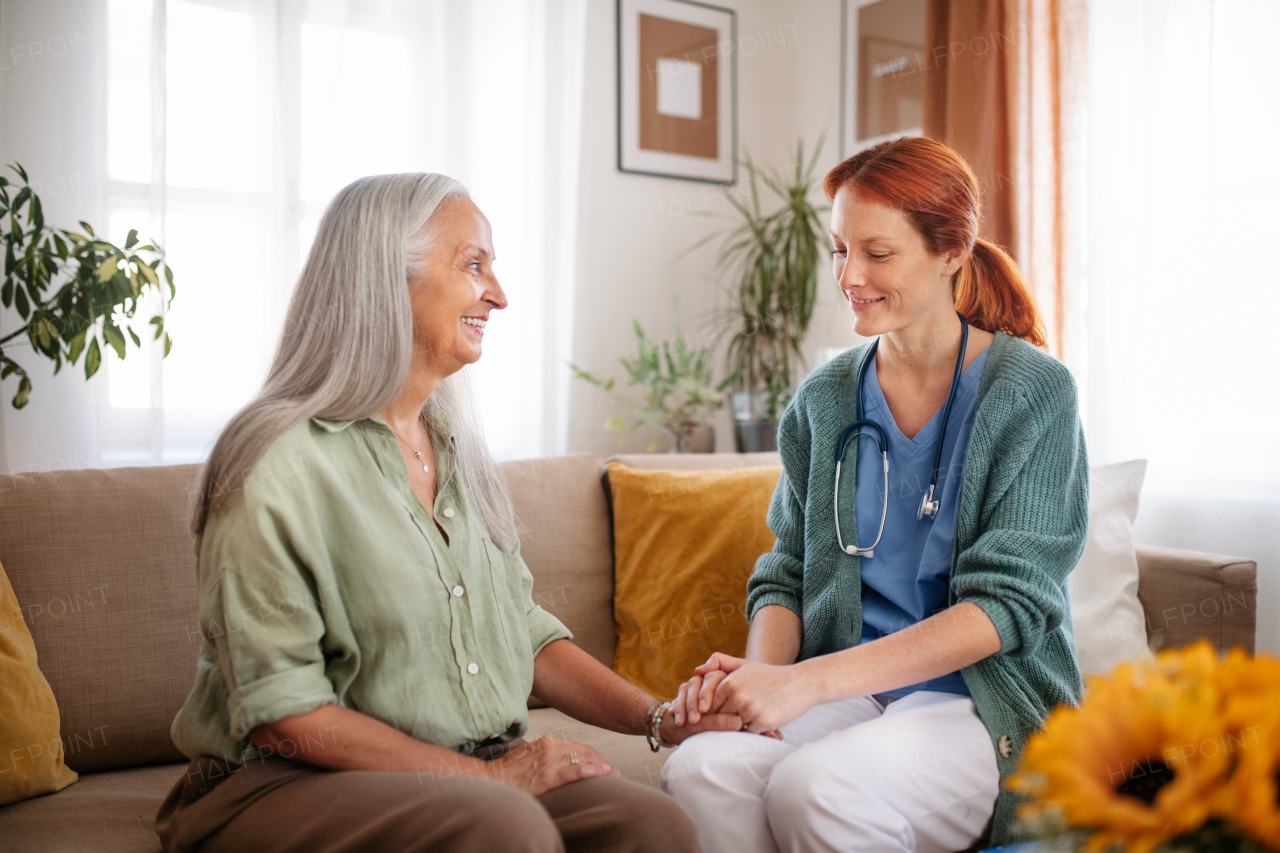 Portrait of caregiver holding hand to senior client.