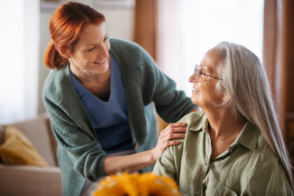 Nurse cosulting with senior woman her health condition at her home.