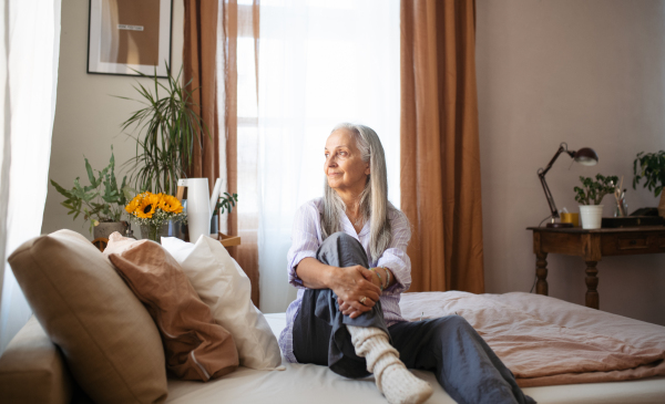 Senior woman resting in a bed during illness.