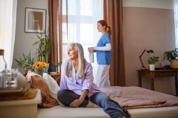 Caregiver helping senior woman in her home.