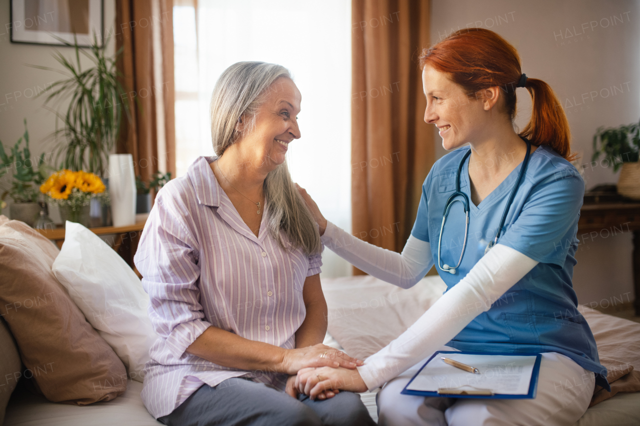 Portrait of caregiver holding hand to senior client.