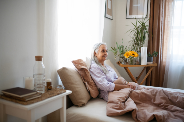 Senior woman resting in a bed during illness.