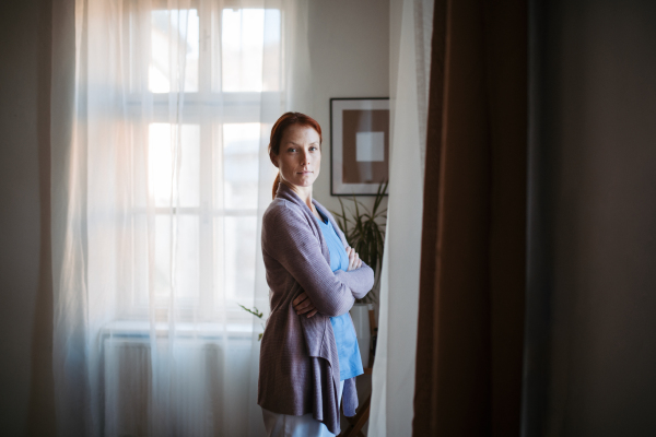 Portrait of young nurse, concept of healthcare in the seniors home. Tired nurse after a long work shift.