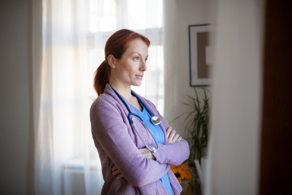 Portrait of young nurse, concept of healthcare in the seniors home. Beautiful female doctor at house call, doctor visiting patient home.