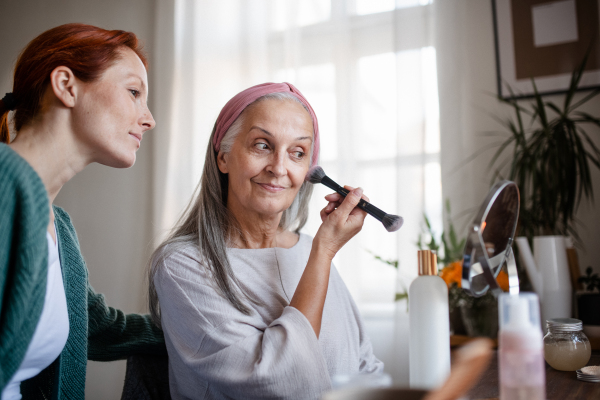 Senior woman making make up herself in home.