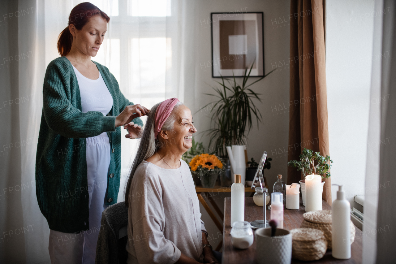 Caregiver helping her senior client with hairstyle.