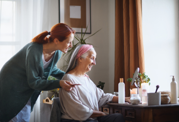 Caregiver helping her senior client with a make up.