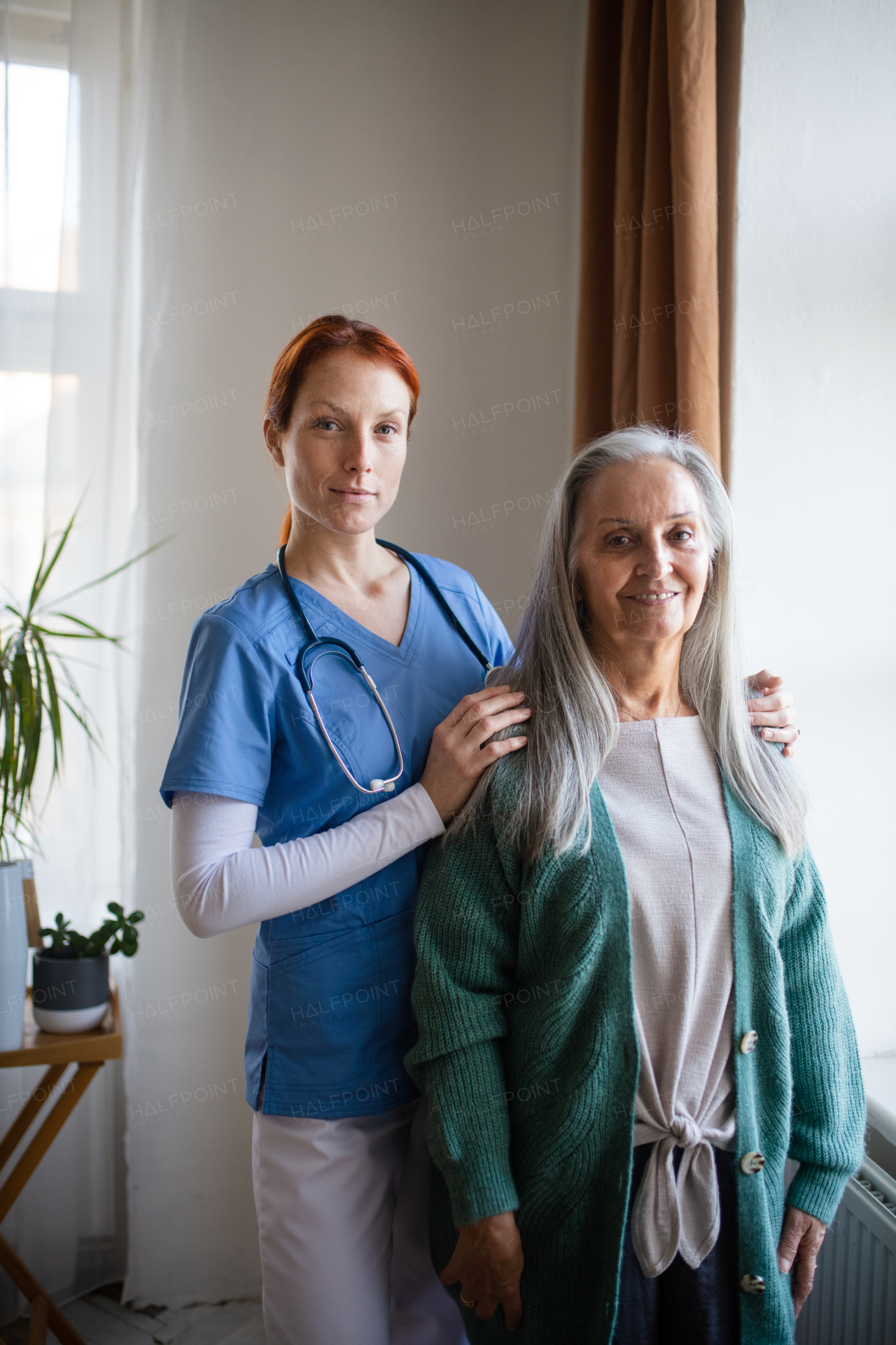 Portrait of senior caregiver and senior woman in her home.