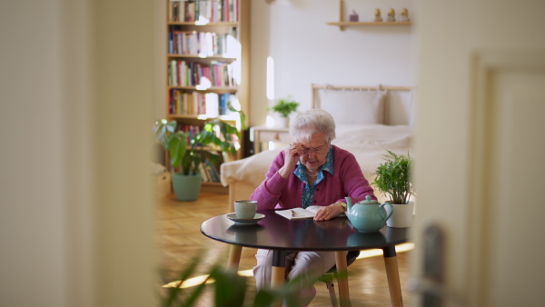 A video of elderly woman solving sudoku puzzles at home, sitting in living room. Sudoku as popular game for aging people, logical thinking, problem solving.