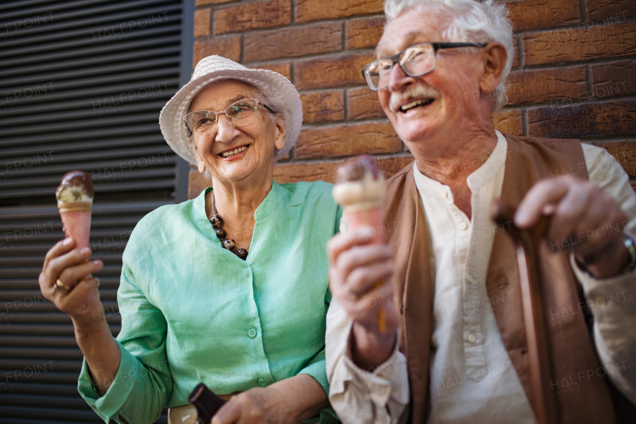 Portrait of senior friends in the city, eating ice cream on a hot summer day. Elderly ladies on summer vacation in the city. Pensioners on group trip. Concept of senior vacation and travel groups, clubs.