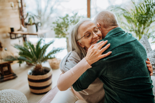 Senior couple in love hugging in their nice modern living room.