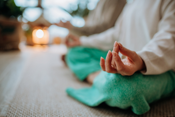 Close-up of senior couple meditating together in their living room during a cold autumn day.