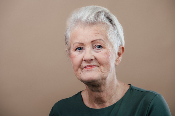 Portrait of smiling senior woman in a studio.