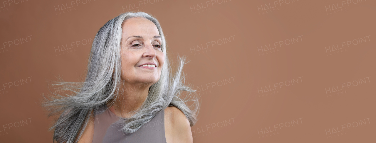 Portrait of smiling senior woman in a studio.