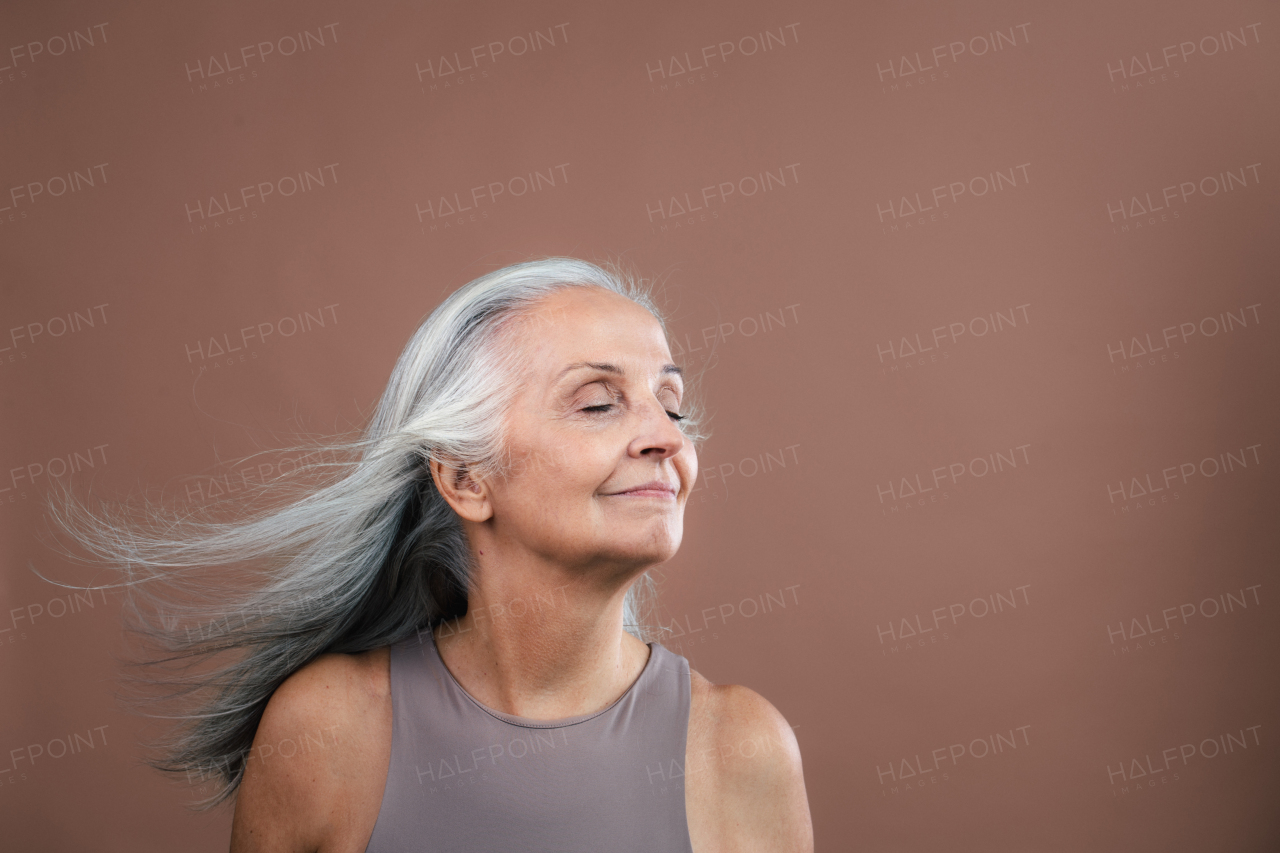 Portrait of smiling senior woman in a studio.