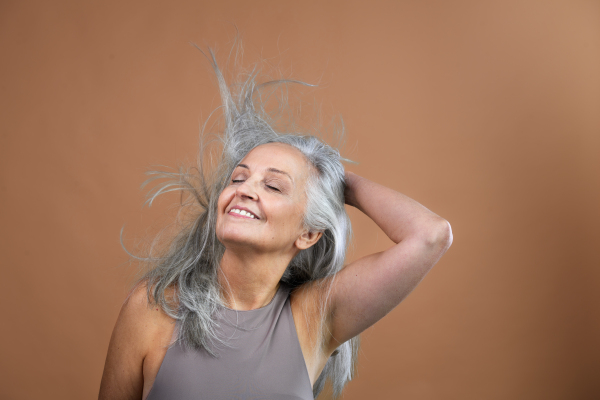 Portrait of smiling senior woman in a studio.