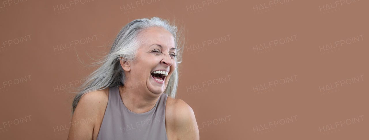 Portrait of smiling senior woman in a studio.