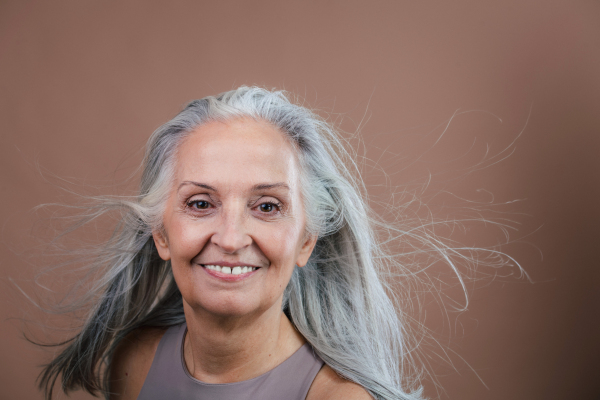 Portrait of smiling senior woman in a studio.