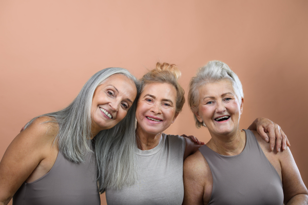 Portrait of happy three senior friends in a studio.