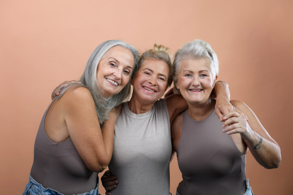 Portrait of happy three senior friends in a studio.