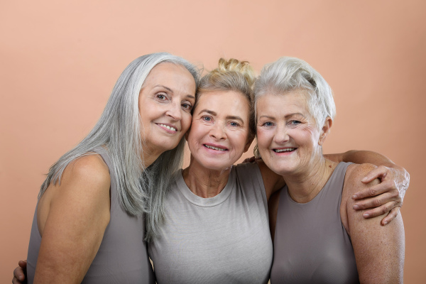 Portrait of happy three senior friends in a studio.