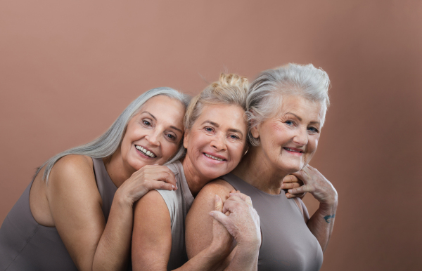 Portrait of happy three senior friends in a studio.