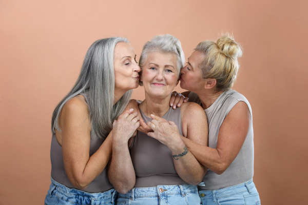 Portrait of happy three senior friends in a studio.