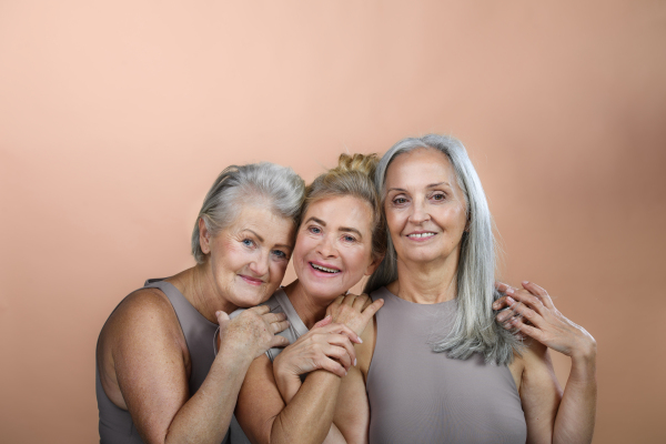 Portrait of happy three senior friends in a studio.