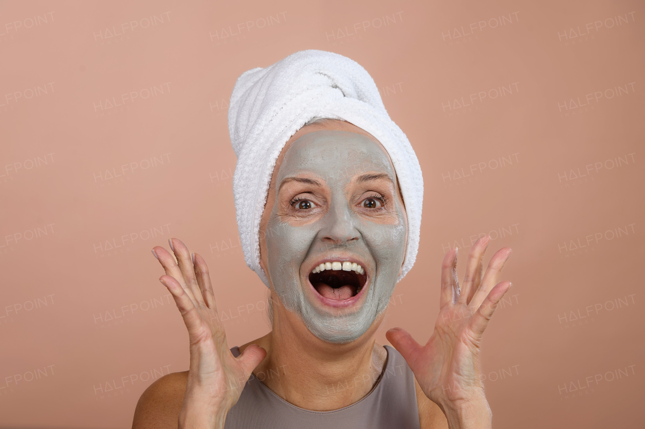 Portrait of excited senior woman with a face-mask, selfcare and skin routine concept.