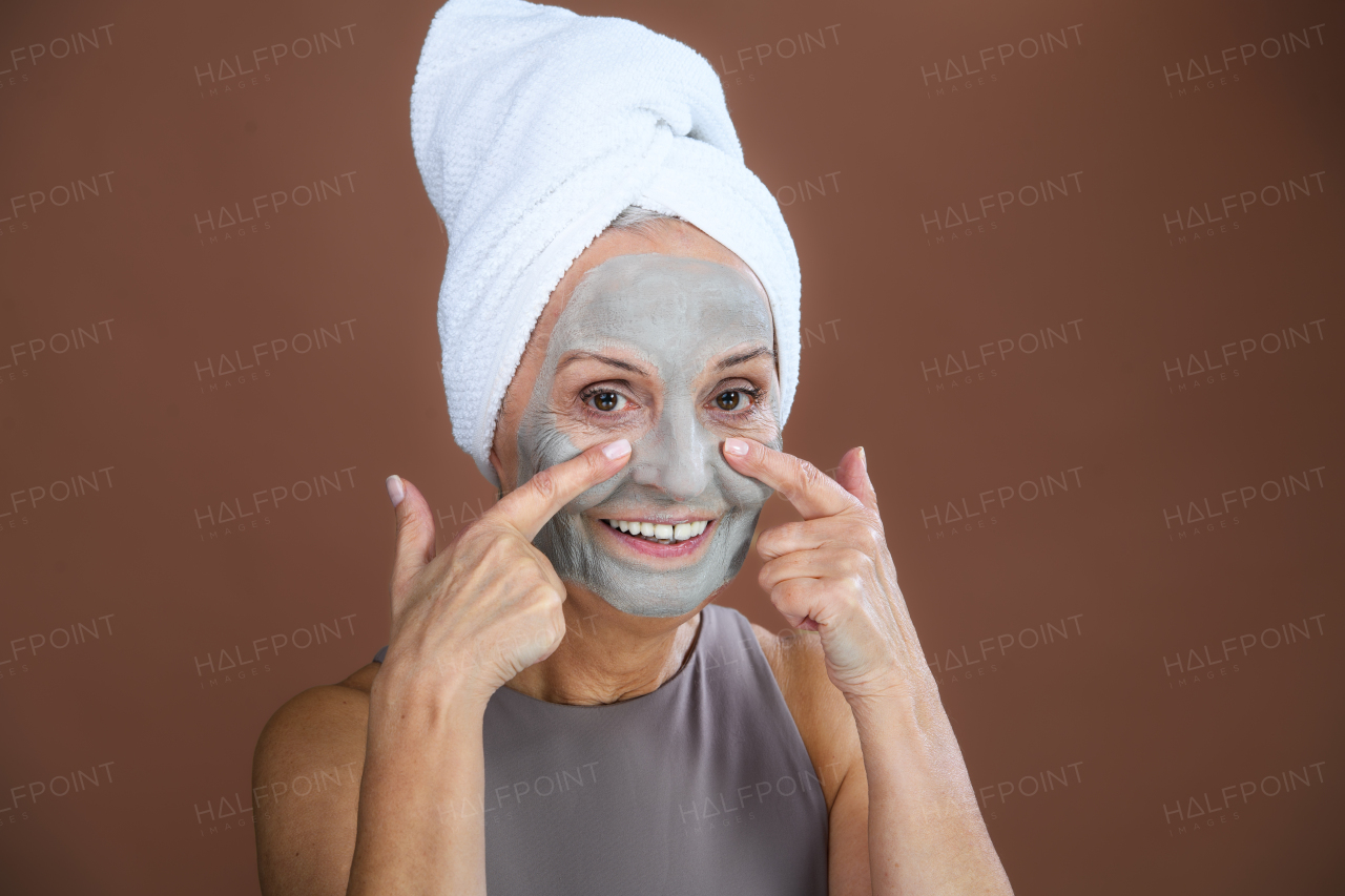 Portrait of excited senior woman with a face-mask, selfcare and skin routine concept.