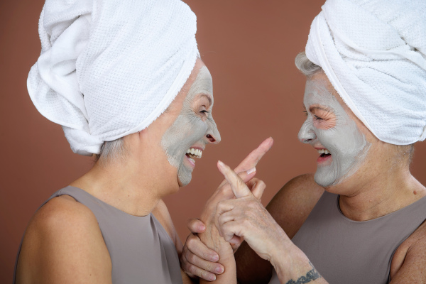 Portrait of happy senior friends with a face-mask, selfcare and skin routine concept.