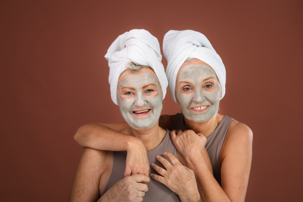 Portrait of happy senior friends with a face-mask, selfcare and skin routine concept.