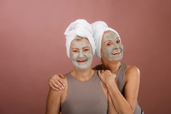 Portrait of happy senior friends with a face-mask, selfcare and skin routine concept.