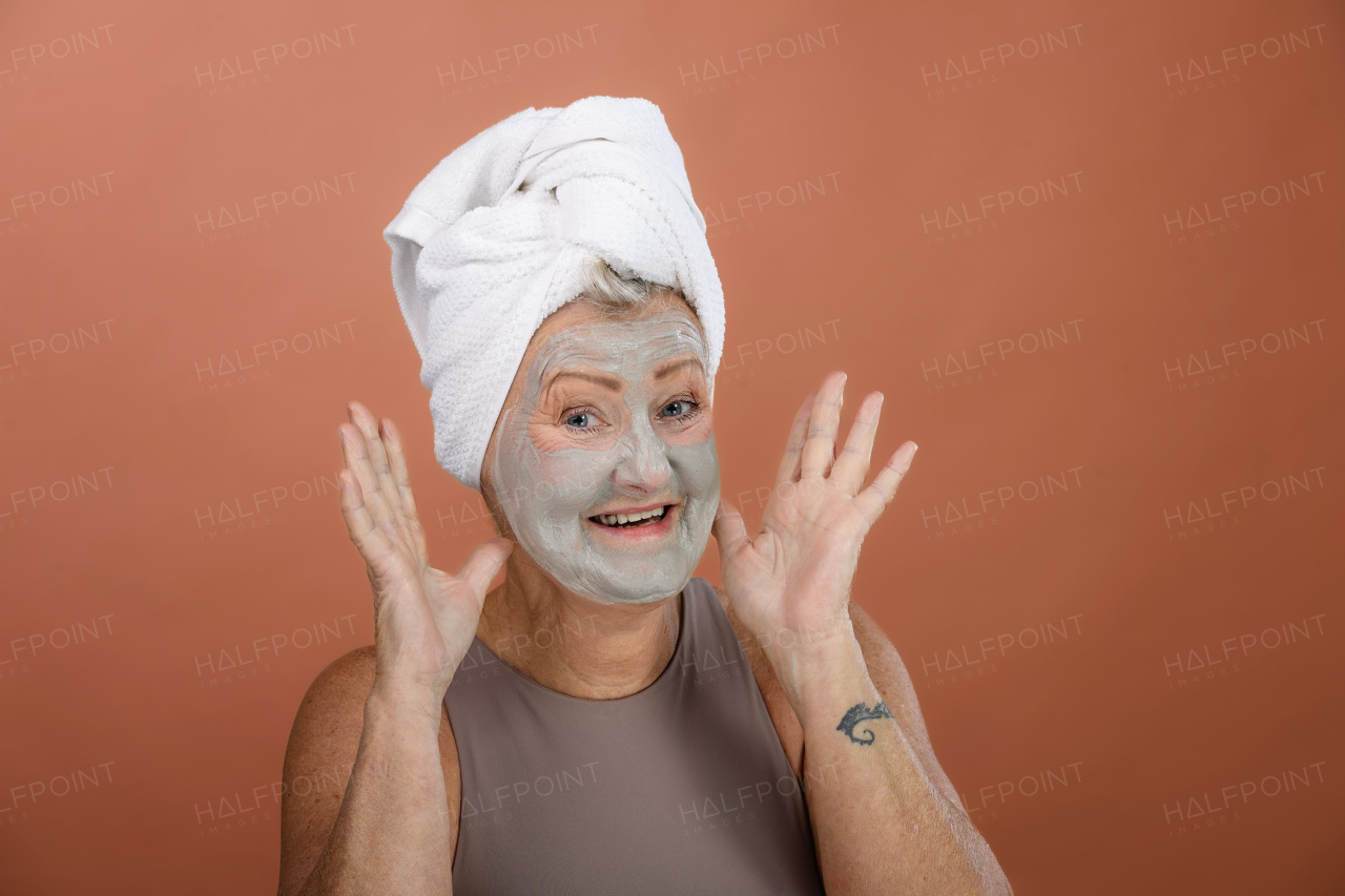 Portrait of excited senior woman with a face-mask, selfcare and skin routine concept.