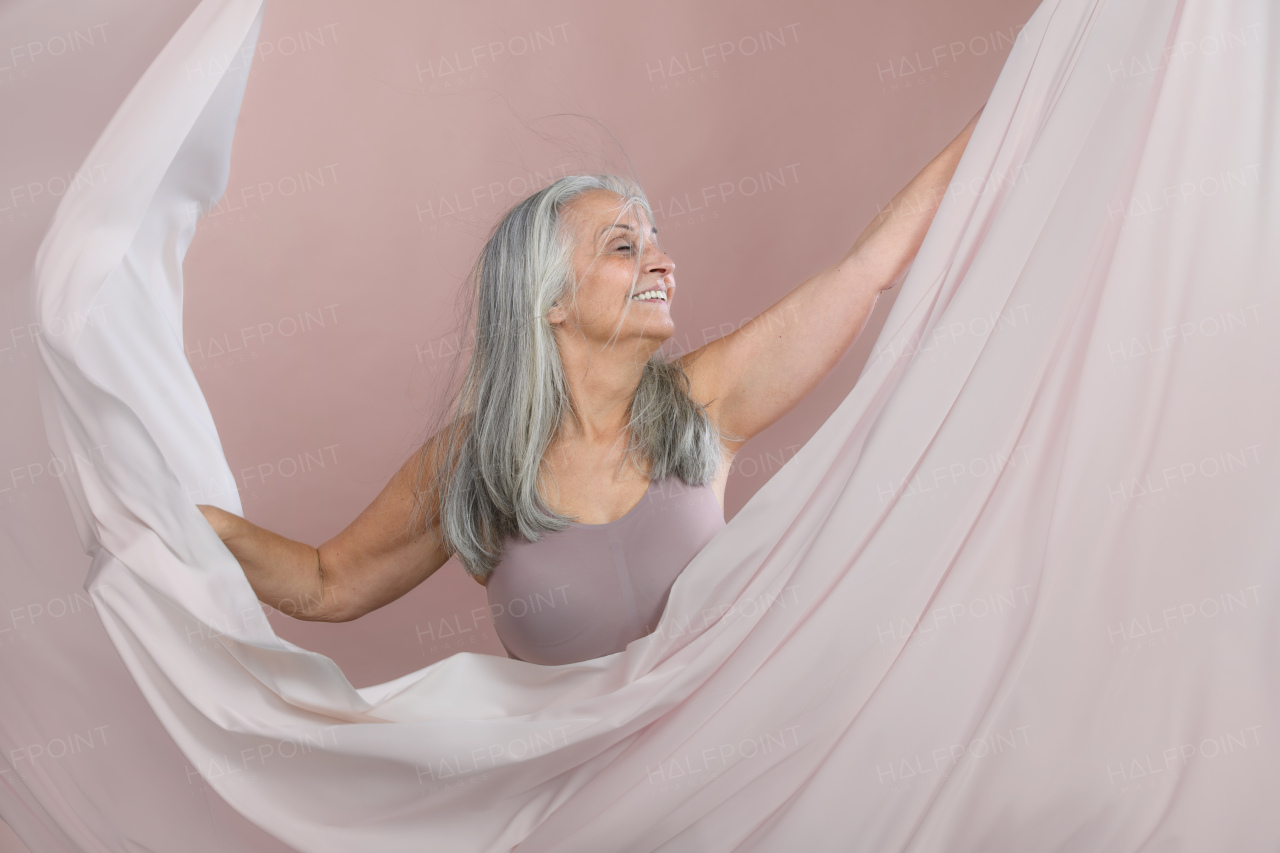 Portrait of happy senior woman in a studio.