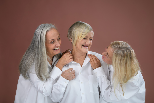 Portrait of three happy senior friends in a studio.