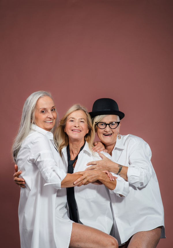 Portrait of three happy senior friends in a studio.