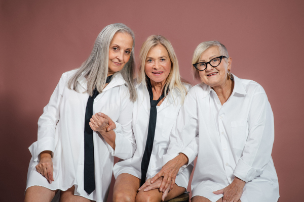 Portrait of three happy senior friends in a studio.