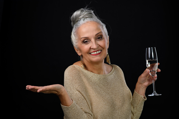 Portrait of happy senior woman with glass of wine, celebration concept.