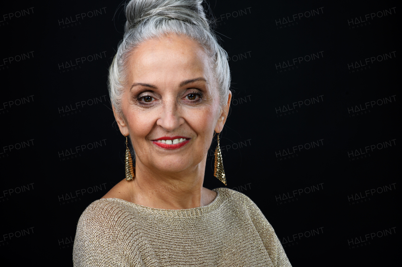 Portrait of well dressed senior woman in party outfit, celebration concept. Isolated on black background.