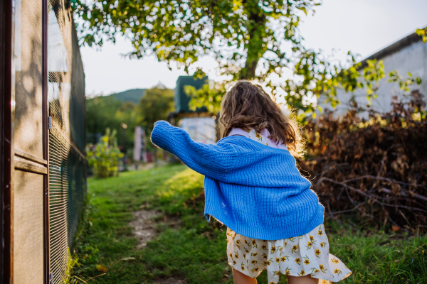 Cute girl running through her grandparents' garden during a warm autumn evening.