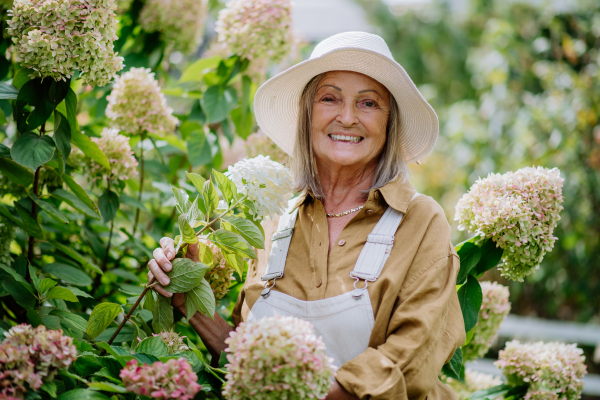 Happy senior woman posing in a flower garden.