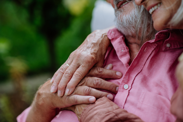 Close-up of stroking hands of happy senior couple in love.