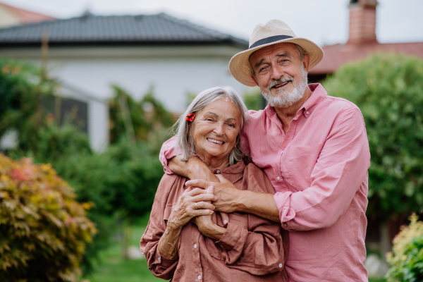 Senior couple in love posing together in a garden.